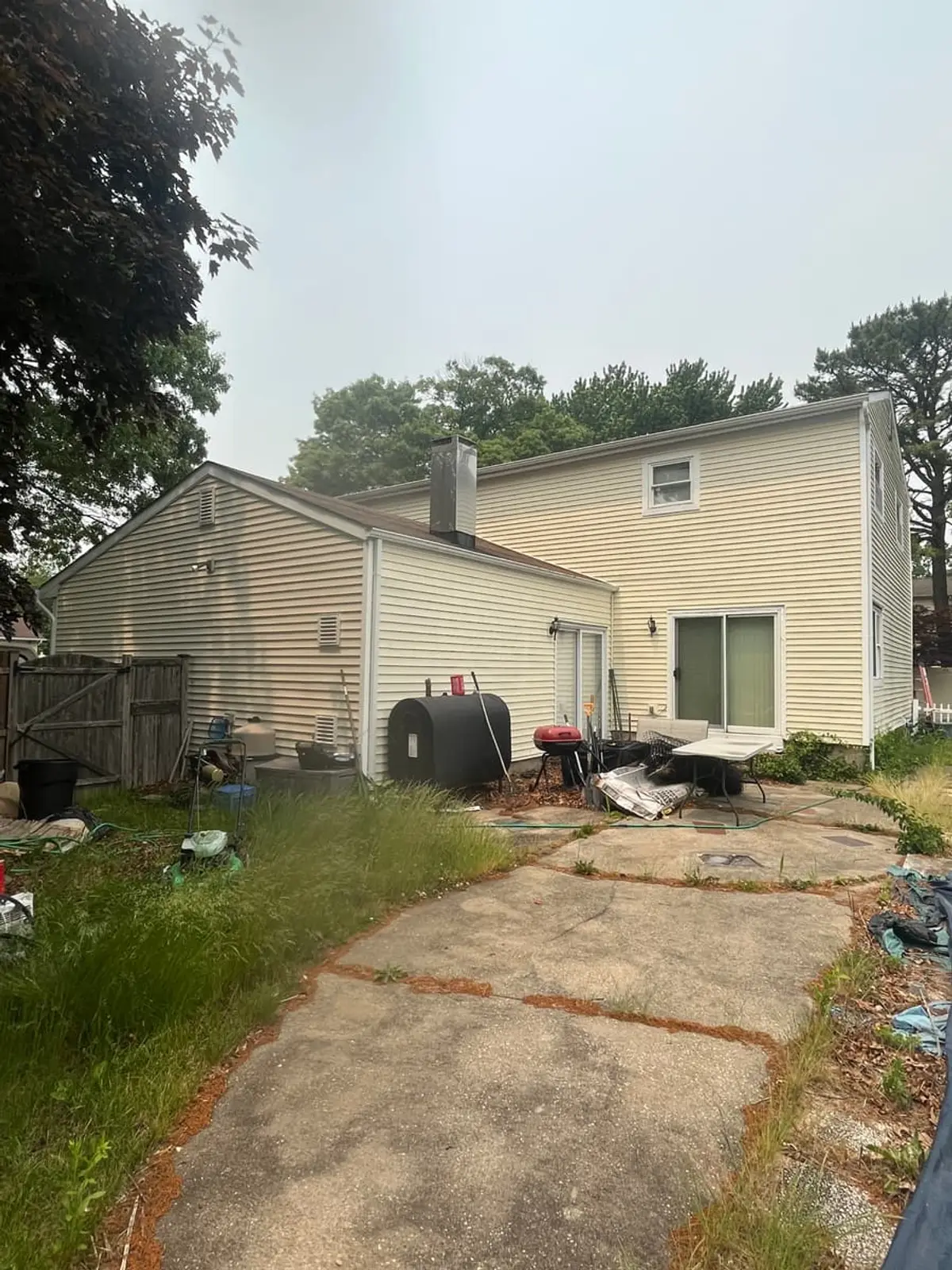 Selling a house with a failed cesspool in Coram: back of a two story house with an outdoor oil tank