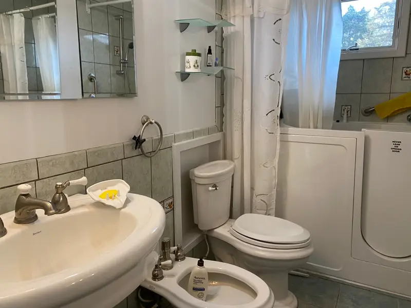 Bathroom with a walk-in tub, bidet and pedestal sink, Coram, NY