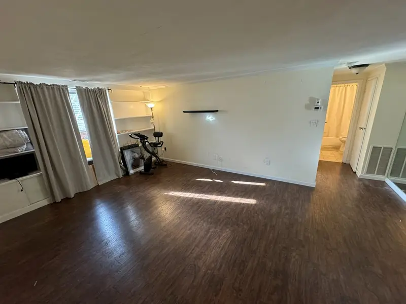 Long living room with dark laminate and built-in shelves, Coram, NY