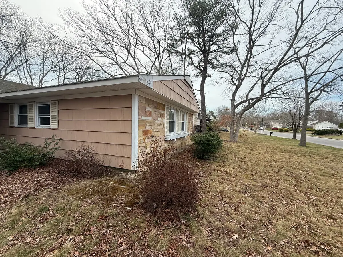 Trying to stop a foreclosure in Coram: shingled ranch with stone trim and bare shrubs