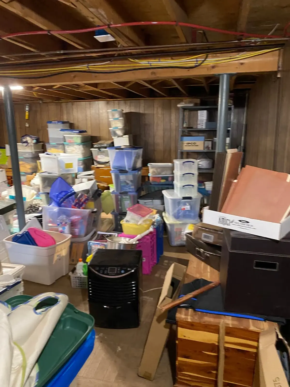 Selling a hoarder house in Coram: unfinished basement packed with plastic bins and boxes